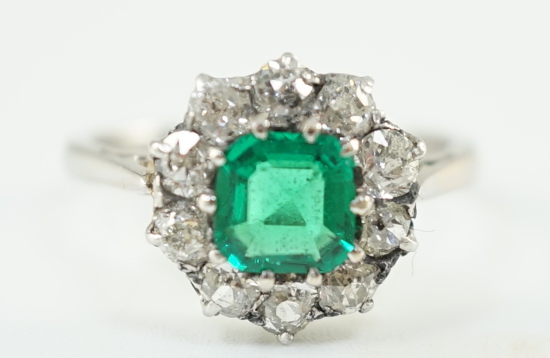 An early to mid 20th century, platinum, octagonal cut emerald and round cut diamond set circular cluster ring